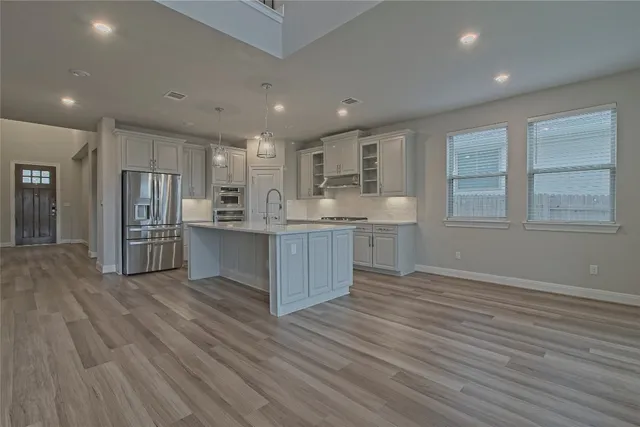 a view of kitchen with wooden floor and electronic appliances