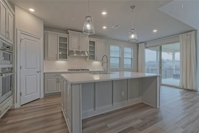 a kitchen with a sink and wooden floor