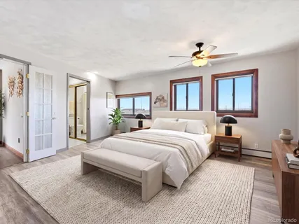 a spacious bedroom with a large bed a chandelier and windows