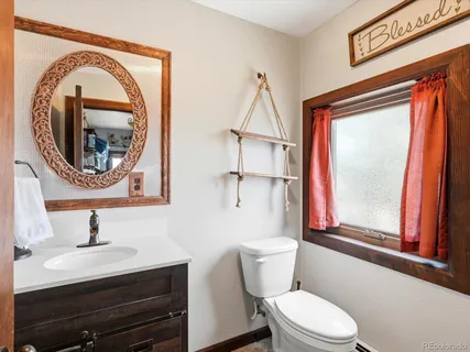 a bathroom with a toilet a sink and a mirror