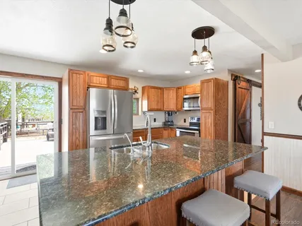 a kitchen with stainless steel appliances granite countertop a sink and a refrigerator