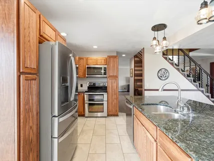 a kitchen with stainless steel appliances granite countertop a refrigerator and a sink