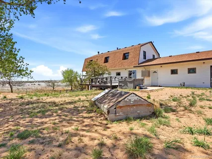 a view of a roof deck with table and chairs a barbeque with wooden floor and fence