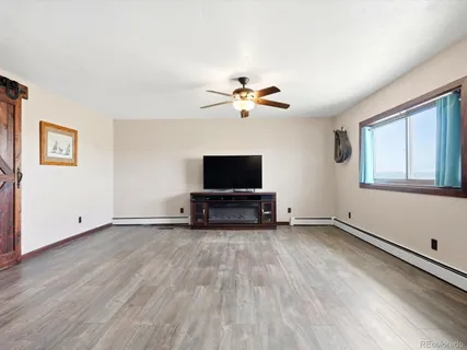 a view of room with hardwood floor and a ceiling fan