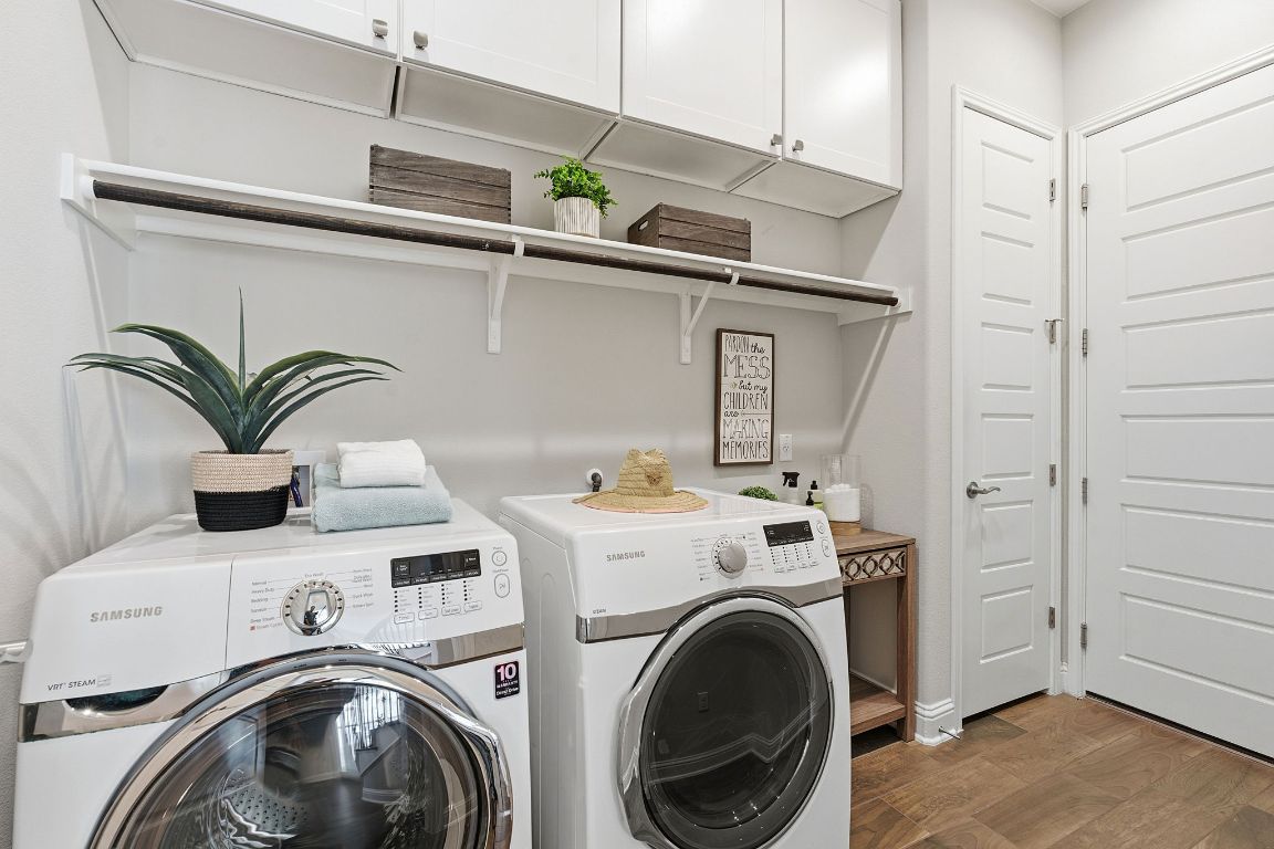 4020 Logan Ridge Drive Cedar Park, TX 78613 - Photo 30 of 40 Washroom featuring dark wood-type flooring, separate washer and dryer, and cabinet space