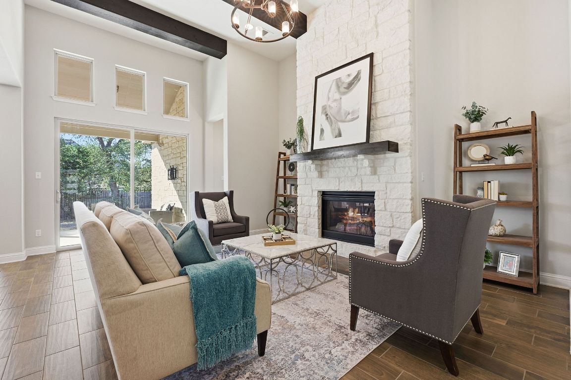4020 Logan Ridge Drive Cedar Park, TX 78613 - Photo 9 of 40 Living area with a fireplace, a towering ceiling, wood tiled floors, and a chandelier