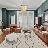 a living room with furniture chandelier and a large window