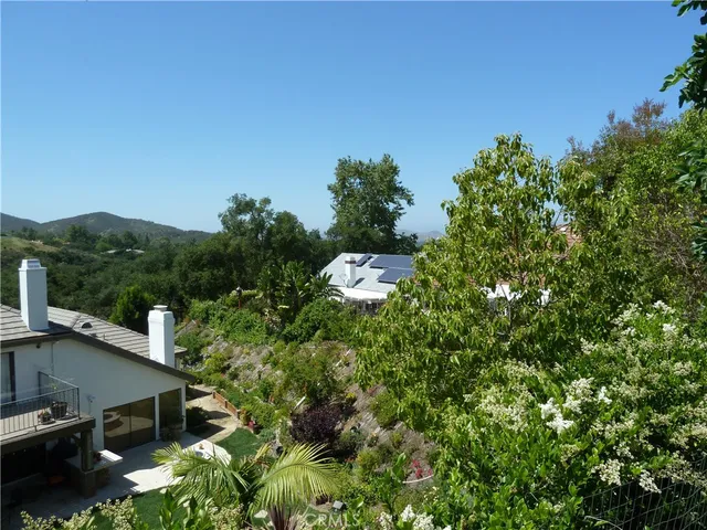 an aerial view of residential house with outdoor space and trees all around