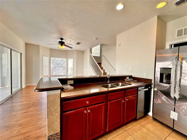 a kitchen with stainless steel appliances granite countertop a sink a stove and a refrigerator