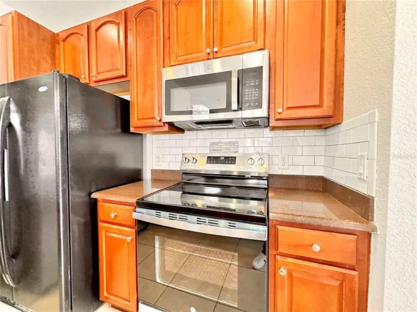 a kitchen with stainless steel appliances granite countertop a stove a sink and a microwave