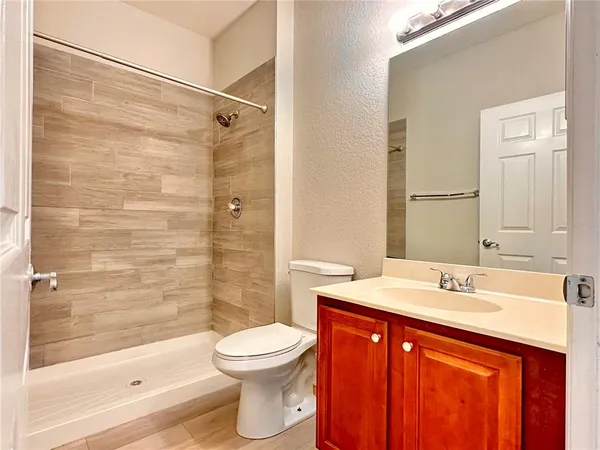 a bathroom with a sink a toilet and shower