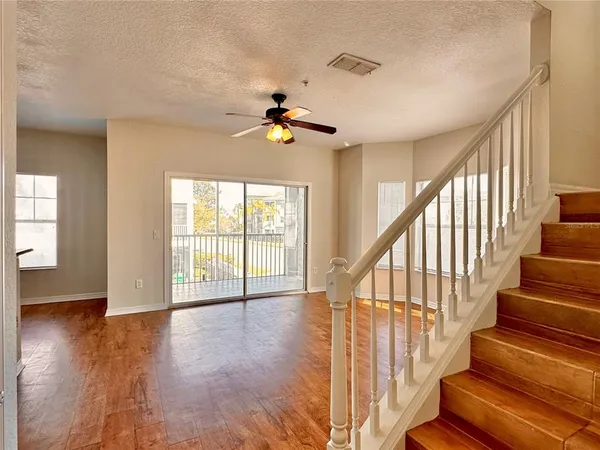 a view of an entryway with wooden floor and a ceiling fan