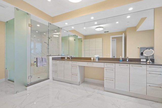a large bathroom with a sink a large mirror and a glass door shower