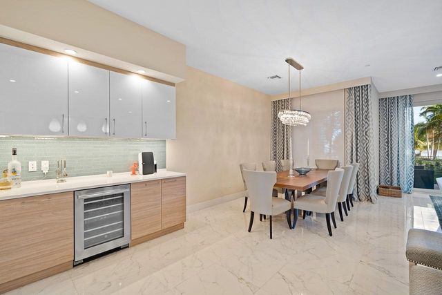 a kitchen with a dining table chairs and white cabinets