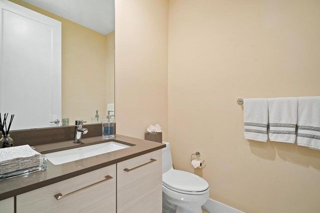 a bathroom with a granite countertop sink a toilet and a mirror
