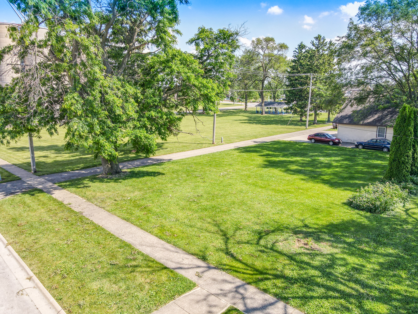 a view of yard with swimming pool and trees in the background