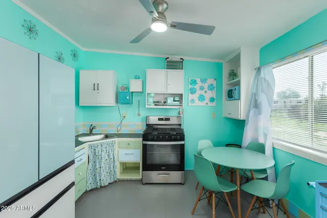 a kitchen with cabinets table and chairs