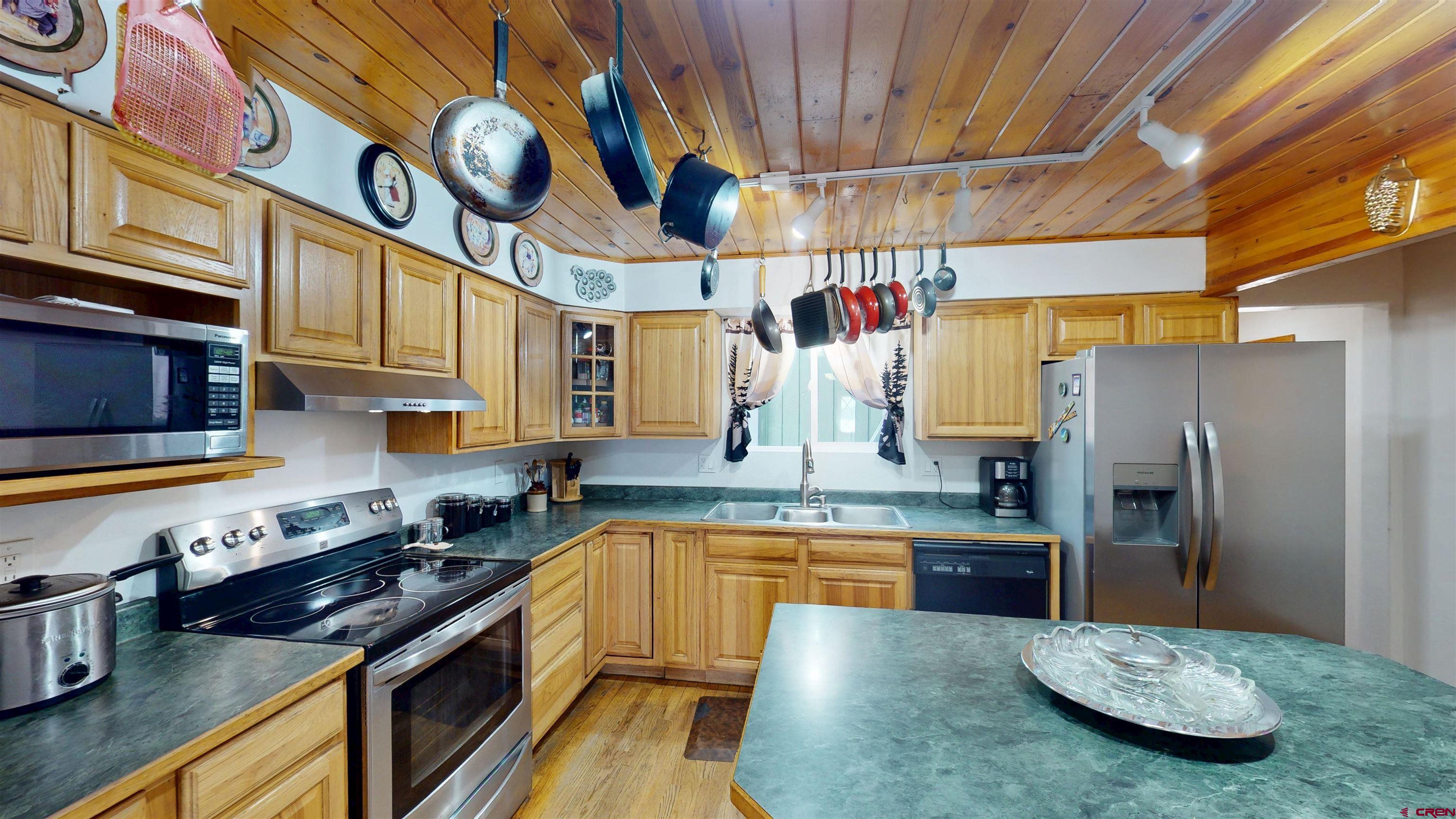 a kitchen with stainless steel appliances granite countertop a sink a stove and refrigerator