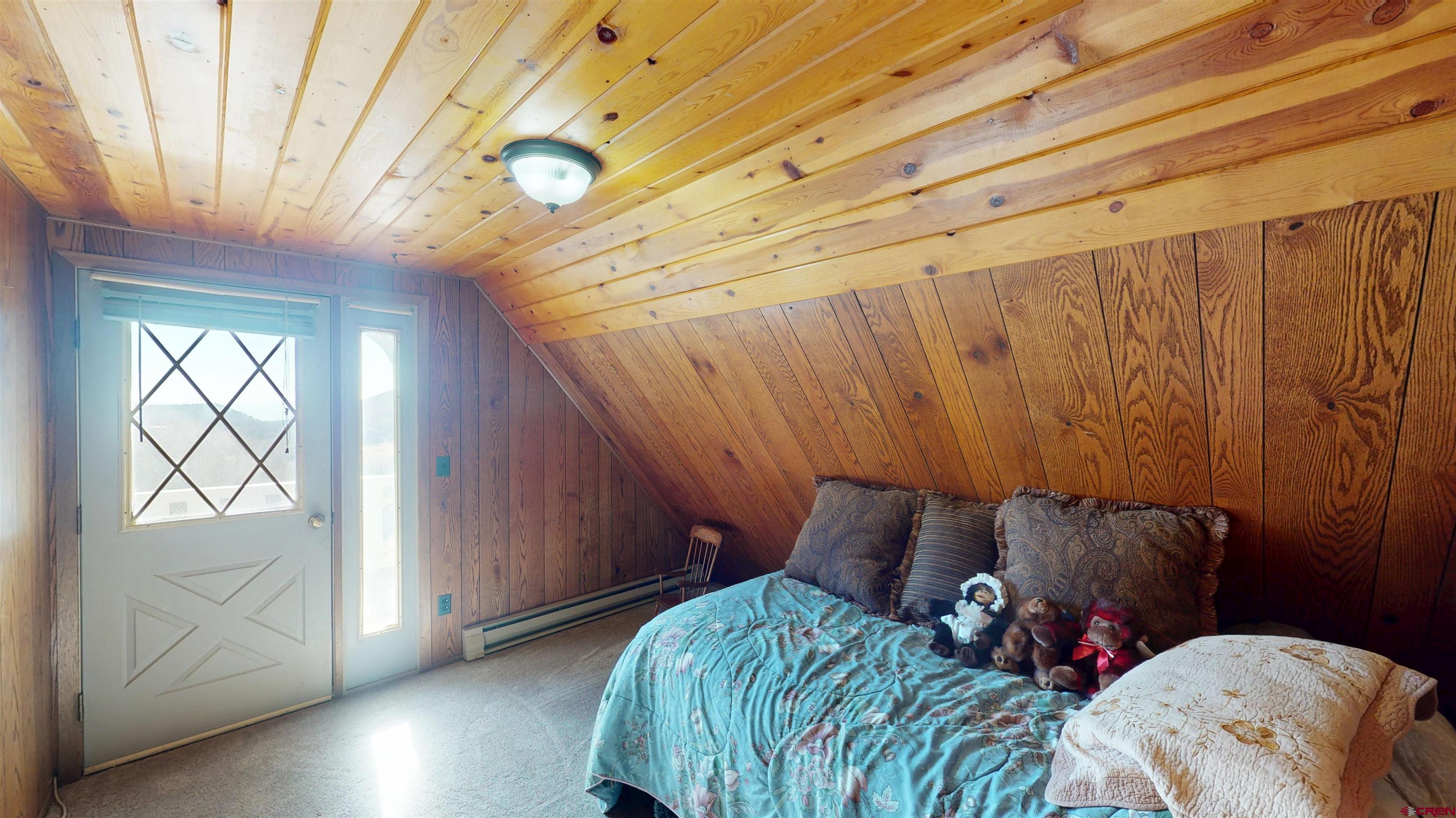 19253 Stevens Gulch Road Paonia, CO 81428 - Photo 14 of 45 a bed sitting in a bedroom next to a window