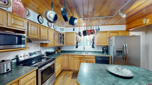 a kitchen with stainless steel appliances granite countertop a sink a stove and refrigerator