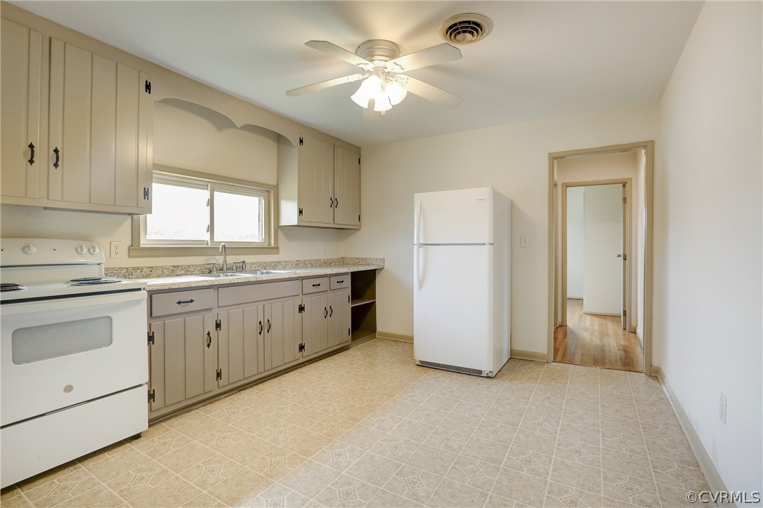 6228 Cross County Road Mineral, VA 23117 - Photo 13 of 26 a kitchen with a refrigerator a sink dishwasher with a dining table and chairs