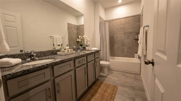 a bathroom with a granite countertop sink toilet and shower