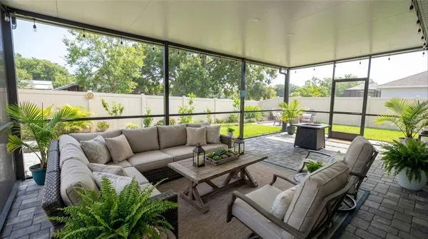 a living room with patio furniture and a floor to ceiling window