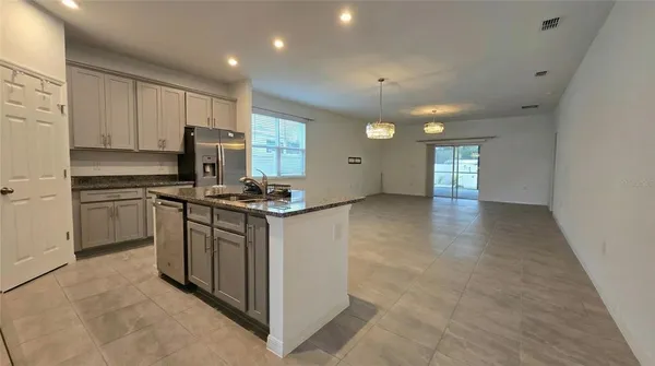 a kitchen with stainless steel appliances granite countertop a stove a sink and a refrigerator