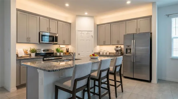 a kitchen with kitchen island granite countertop wooden cabinets and stainless steel appliances