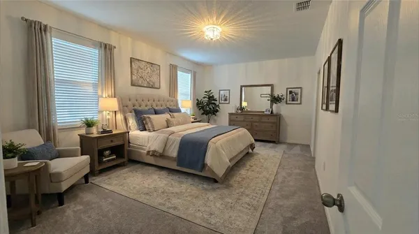 a spacious bedroom with a bed and lamp