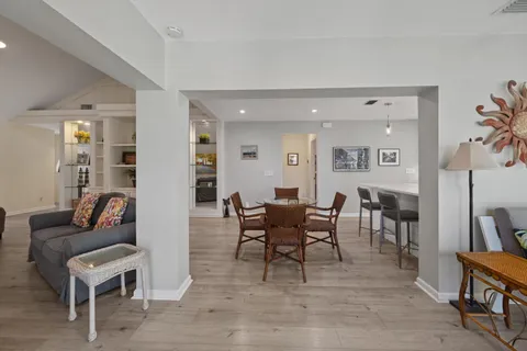 a living room with furniture a dining table and a bookshelf