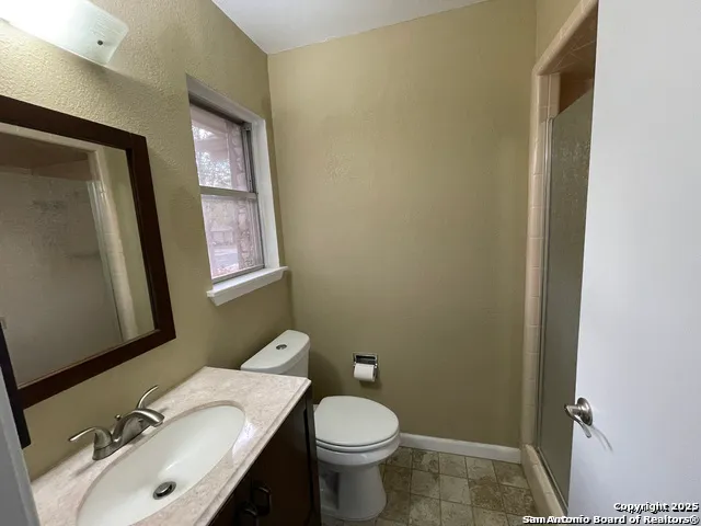 a bathroom with a sink vanity mirror and toilet