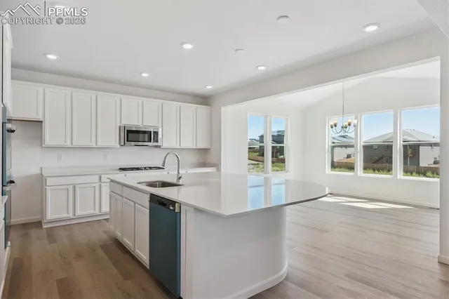 a kitchen with stainless steel appliances granite countertop a lot of counter space and wooden floors