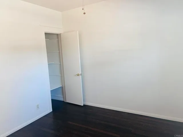 an empty room with wooden floor and a window