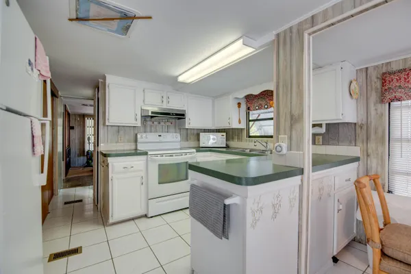 a kitchen with kitchen island granite countertop a sink appliances cabinets and furniture