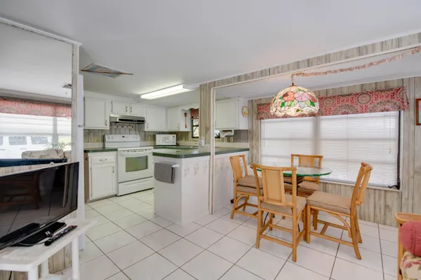 a kitchen with cabinets and chairs