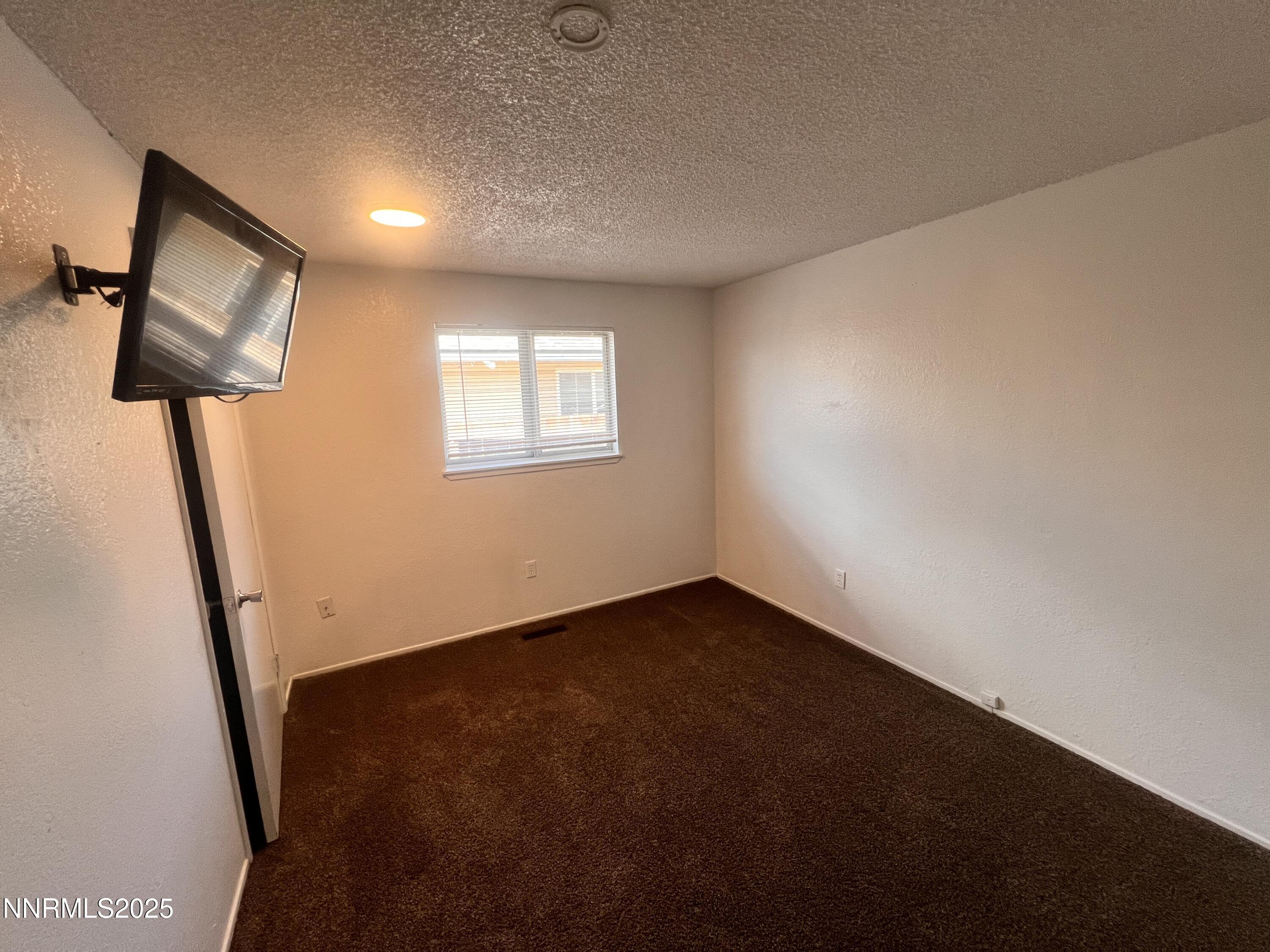 13790 Mt Babcock Street Reno, NV 89506 - Photo 8 of 18 an empty room with wooden floor and windows