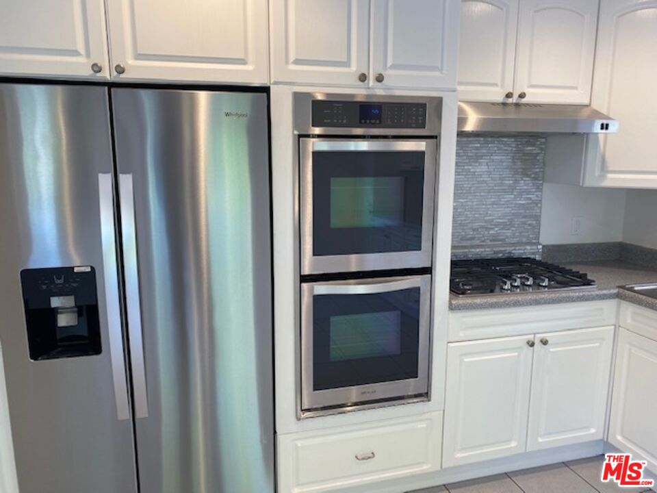 600 Luton Drive Glendale, CA 91206 - Photo 6 of 42 a kitchen with granite countertop white cabinets and stainless steel appliances
