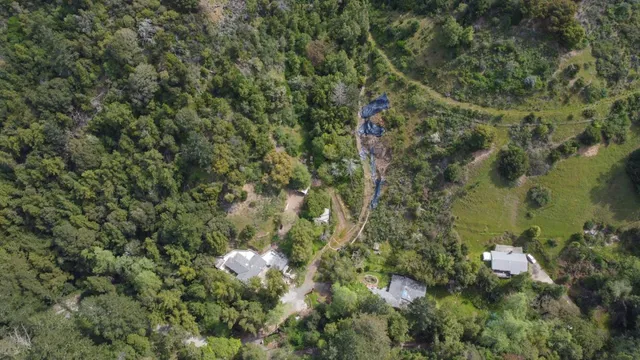 an aerial view of a house with a yard and lake view