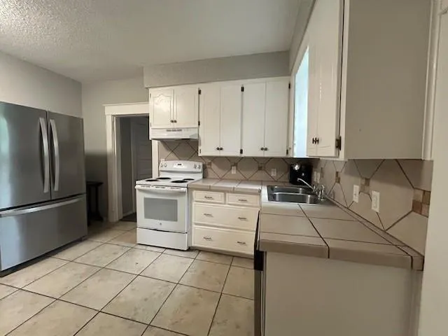 a kitchen with a stove cabinets and a refrigerator