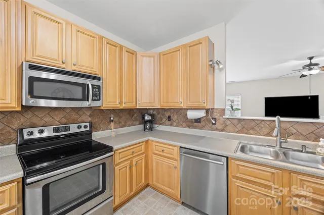 a kitchen with stainless steel appliances granite countertop a sink stove and microwave