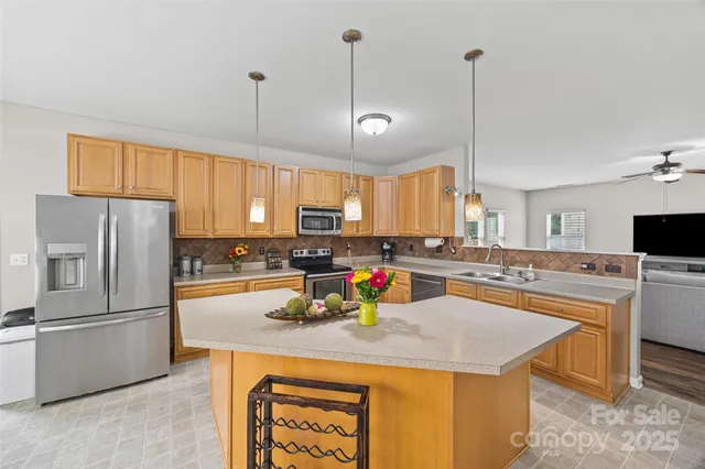 a kitchen with stainless steel appliances granite countertop a sink a stove and a refrigerator