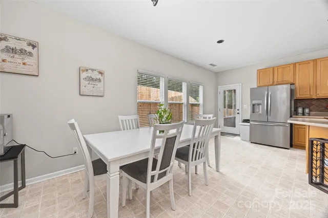 a view of a dining room with furniture and a refrigerator