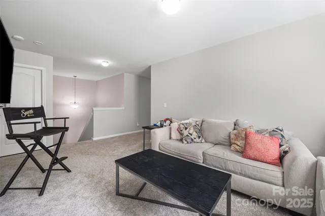 a living room with furniture and a dining table with chair