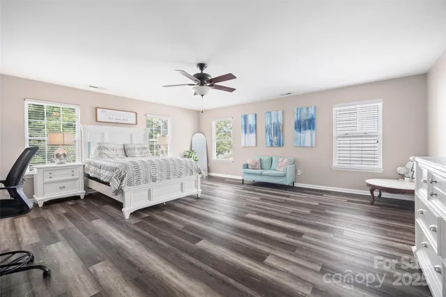 a spacious bedroom with a bed a couch and a large window