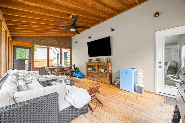 a bedroom with furniture a flat screen tv and a floor to ceiling window