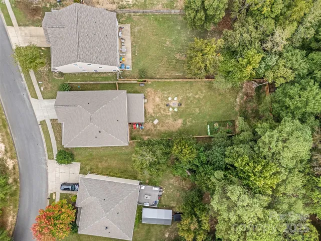 an aerial view of a house with a yard and large tree