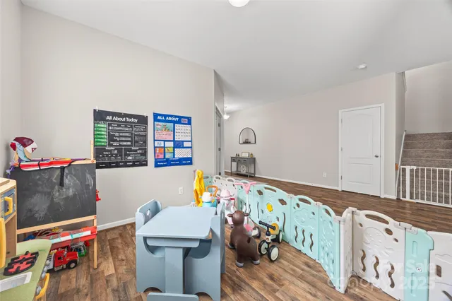 a bedroom with baby bed toys and paintings on the wall