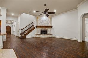 961 Deer Run Prosper, TX 75078 - Photo 8 of 12 a view of an empty room with wooden floor and a fireplace