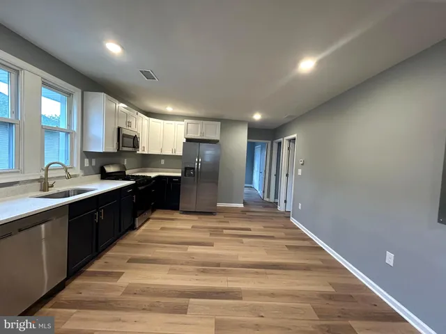a large kitchen with kitchen island a sink dishwasher stove and cabinets